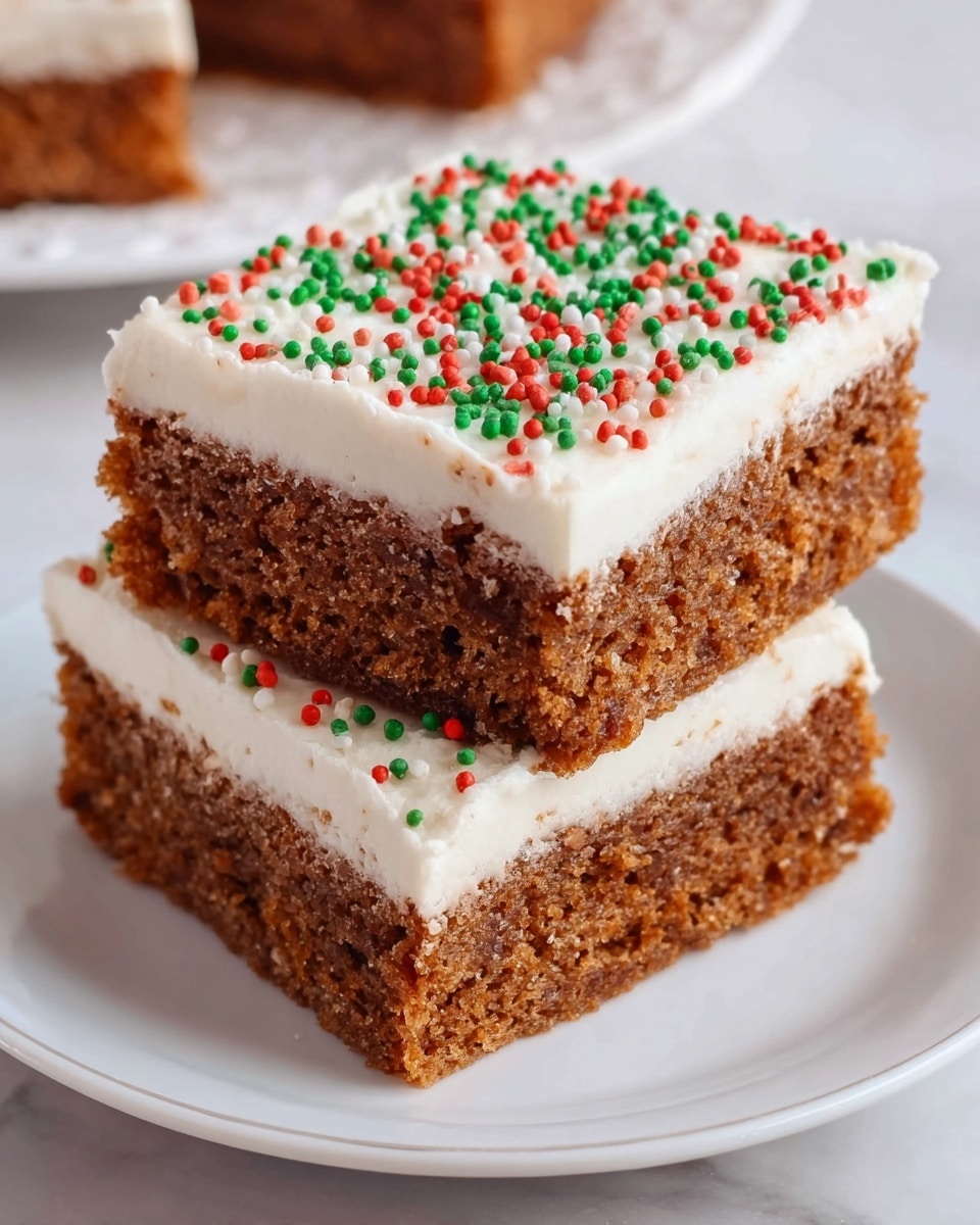 The image shows two square pieces of layered cake stacked on a white plate. Each piece has three layers: two thick, brown cake layers with a soft, crumbly texture, separated and topped by thick, smooth white frosting. The top layer of frosting is decorated with small red and green sprinkles. The plate sits on a white marbled surface. Photo taken with an iphone --ar 4:5 --v 7