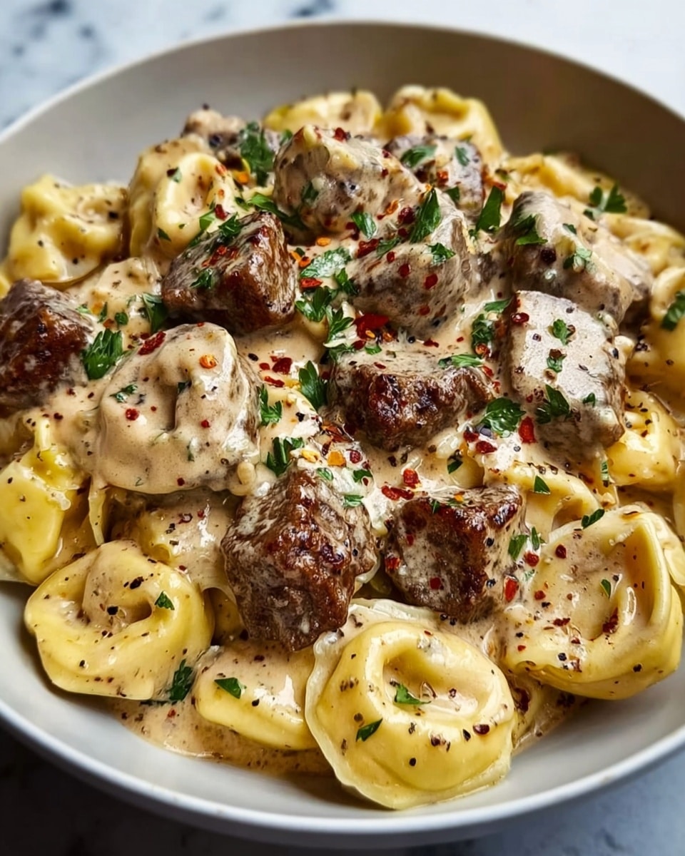 A close-up image of a white bowl filled with three layers: the bottom layer is tortellini pasta in light yellow with smooth, soft textures, arranged closely together; the middle layer has browned meat chunks with a slightly crispy texture and a dark brown color, scattered evenly over the pasta; the top layer consists of creamy sauce in a light beige color, speckled with black pepper and red chili flakes, drizzled over the meat and pasta. Fresh green parsley pieces are sprinkled on top for color contrast. The bowl is set on a white marbled surface. photo taken with an iphone --ar 4:5 --v 7