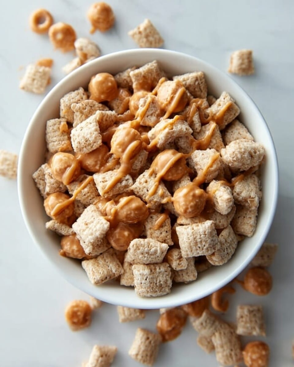 A white bowl filled with a mix of light beige square cereal pieces and small round beige cereal pieces. The cereal squares have a rough texture and are drizzled with a shiny caramel sauce that creates thin streaks over the top layer. Some of the round cereal pieces are also visible around the edges and scattered on a white marbled surface around the bowl. The lighting is soft and the photo is taken from above, showing the bowl full of cereal and caramel sauce. photo taken with an iphone --ar 4:5 --v 7