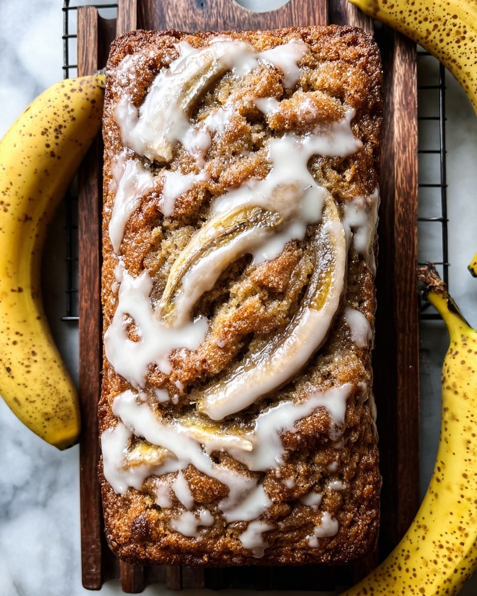 A loaf of banana bread with three visible layers, placed on a dark wooden cooling rack over a white marbled surface. The bottom layer is a rich golden brown cake base, slightly crispy on the edges. The middle layer contains swirls of cinnamon creating a dark brown pattern throughout. The top layer is thick white glaze drizzled unevenly, partially covering the cinnamon swirls, with three banana slices embedded in the glaze, adding light yellow spots. Around the cooling rack are three ripe yellow bananas with brown spots on their skins. Photo taken with an iphone --ar 4:5 --v 7